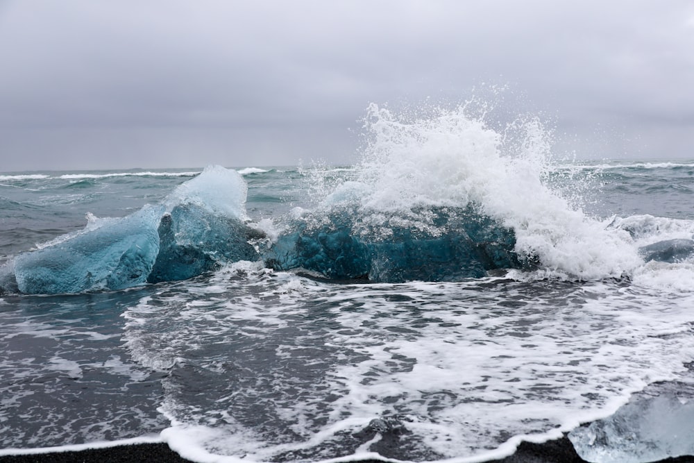 a wave crashes on a rock in the ocean