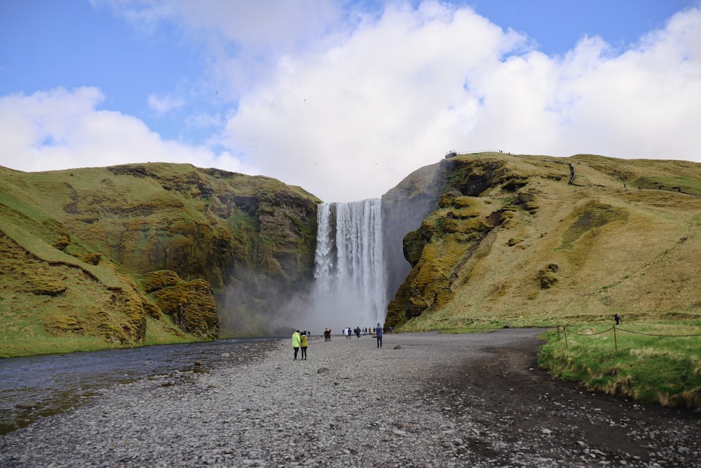 a group of people standing in front of a waterfall