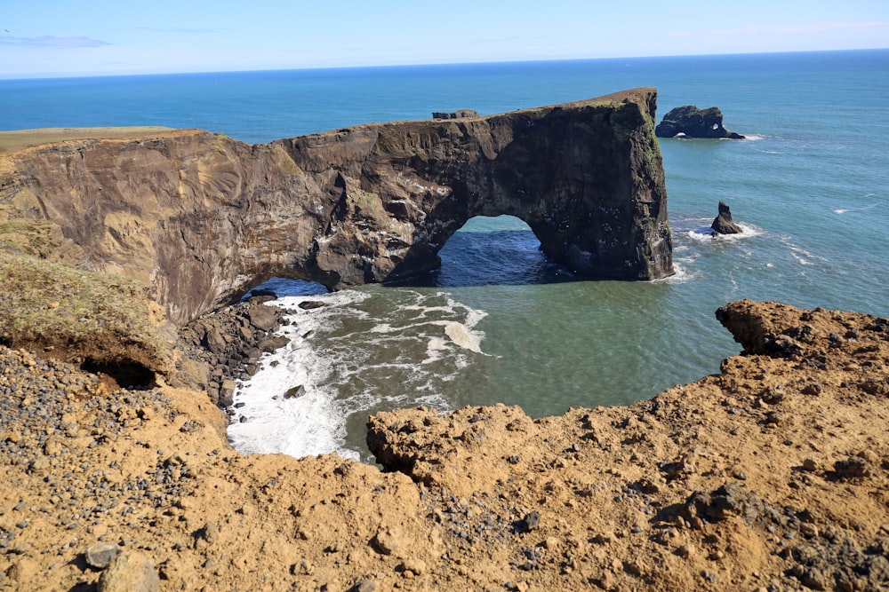 a rocky cliff with a hole in the middle of it