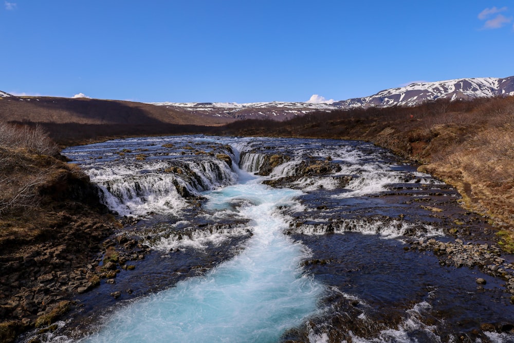 a river running through a valley surrounded by mountains