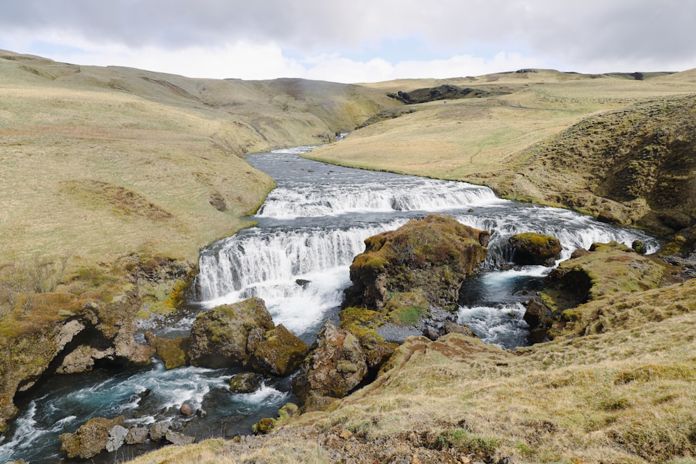 a river running through a lush green hillside