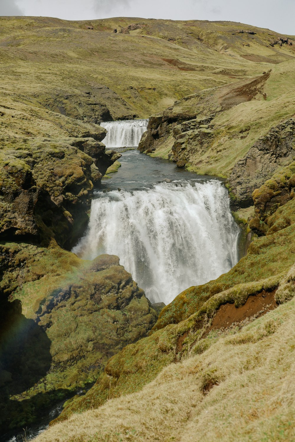 a waterfall with a rainbow in the middle of it