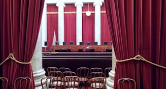 a room with red curtains and chairs in it
