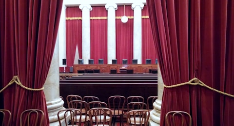 a room with red curtains and chairs in it