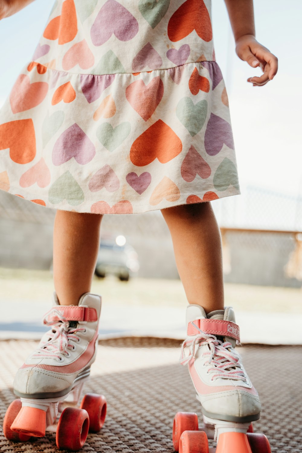 a little girl standing on top of a skateboard