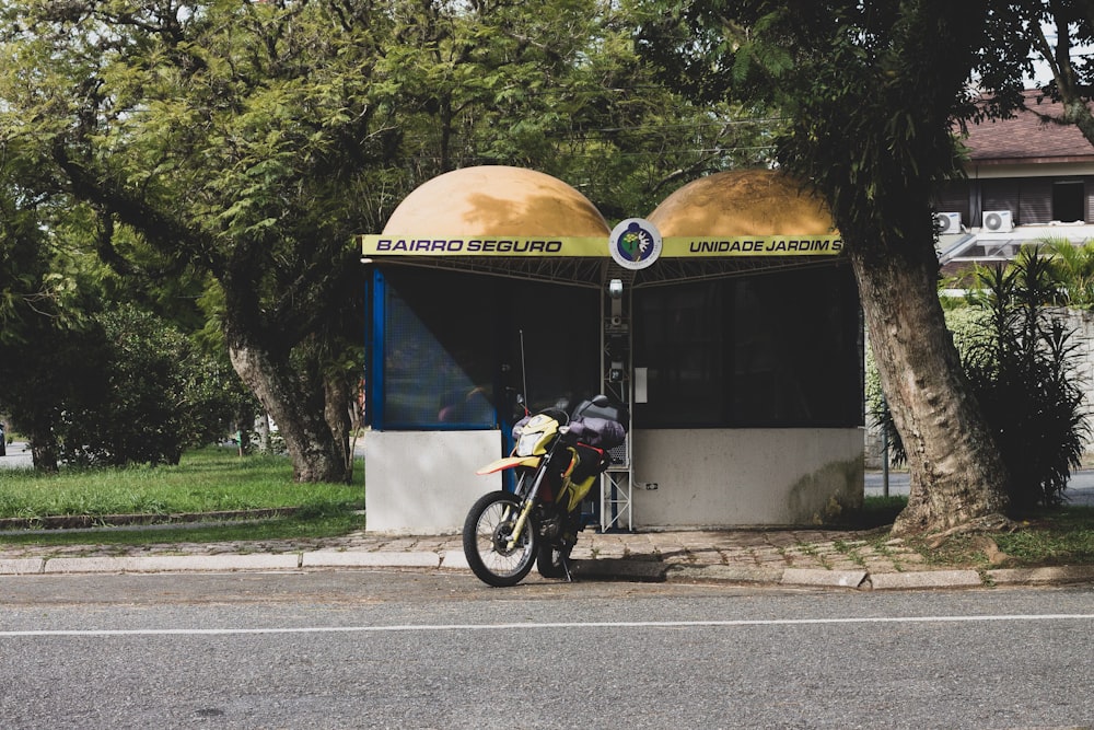 a motorcycle parked in front of a small kiosk