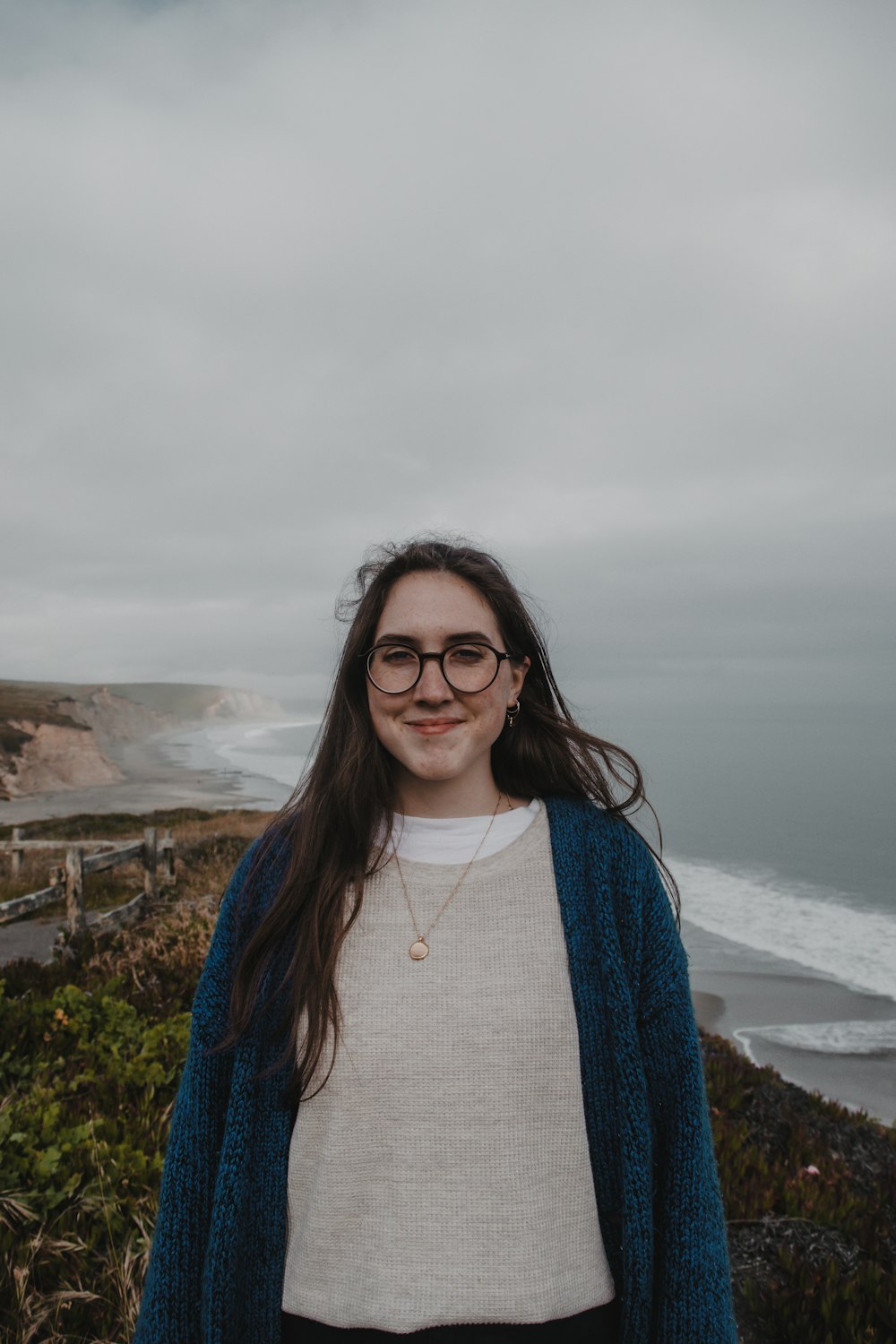 a woman standing on a cliff overlooking the ocean