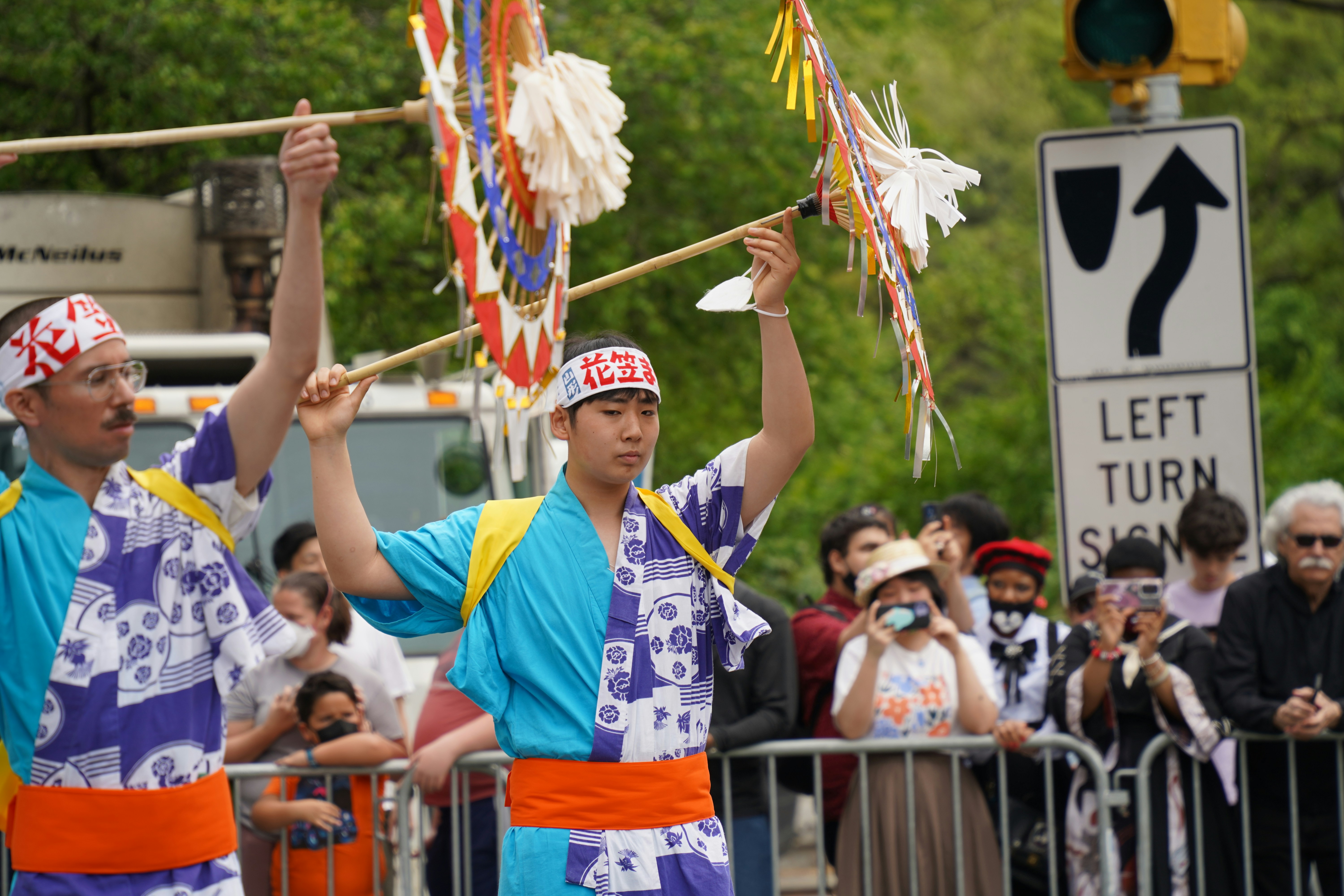 A couple of men holding onto some sticks photo – Free Parade Image on ...