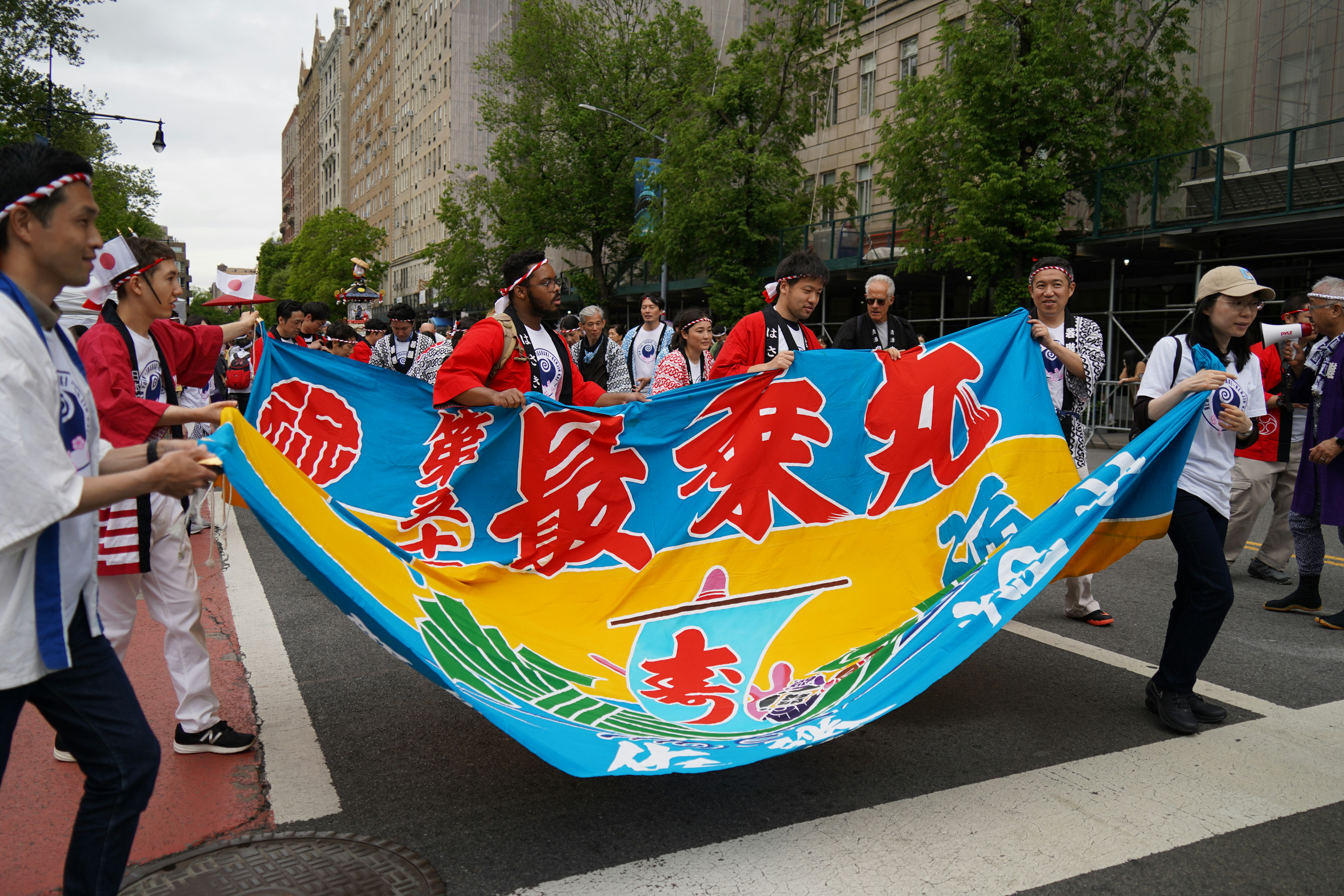 a group of people walking down a street holding a banner