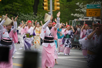 A vibrant festival parade with dancers in colorful kimonos and traditional masks.