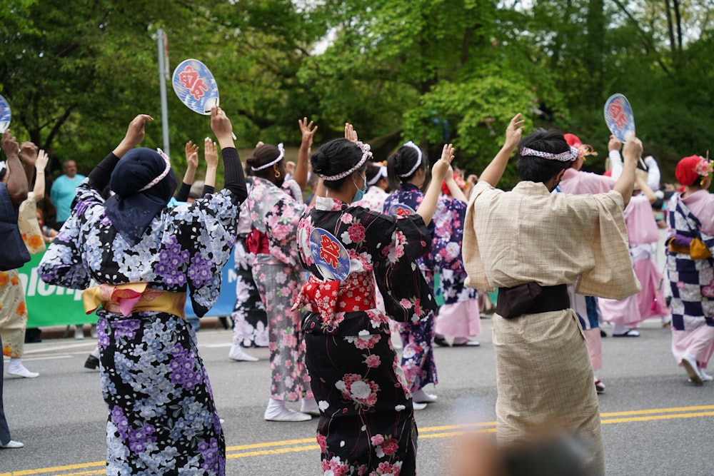 a group of women in kimonos walking down a street