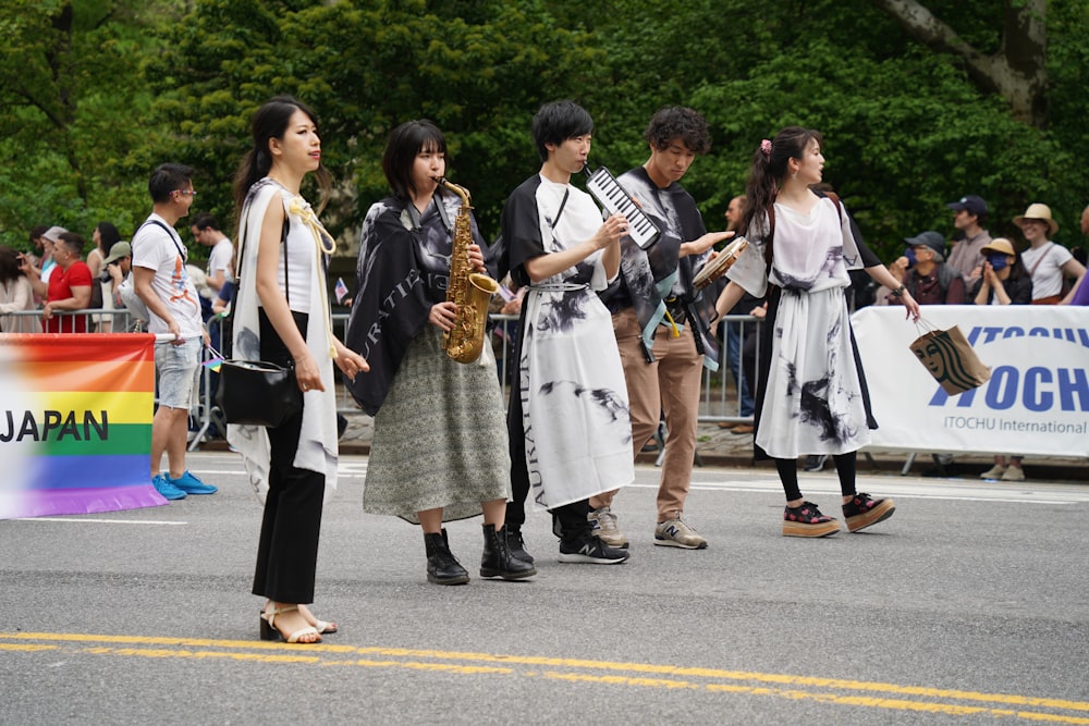 a group of people standing on the side of a road