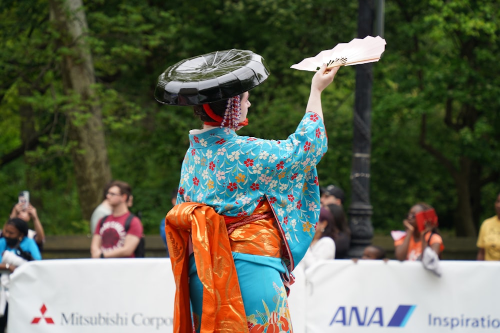 a woman in a kimono holding a paper in her hand