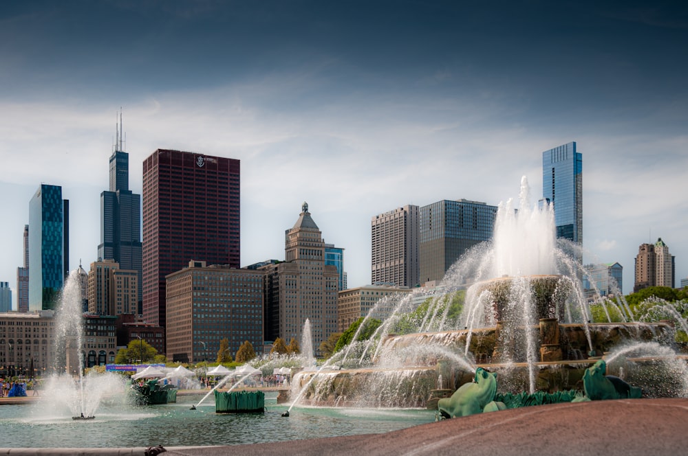 a city skyline with a fountain in the foreground