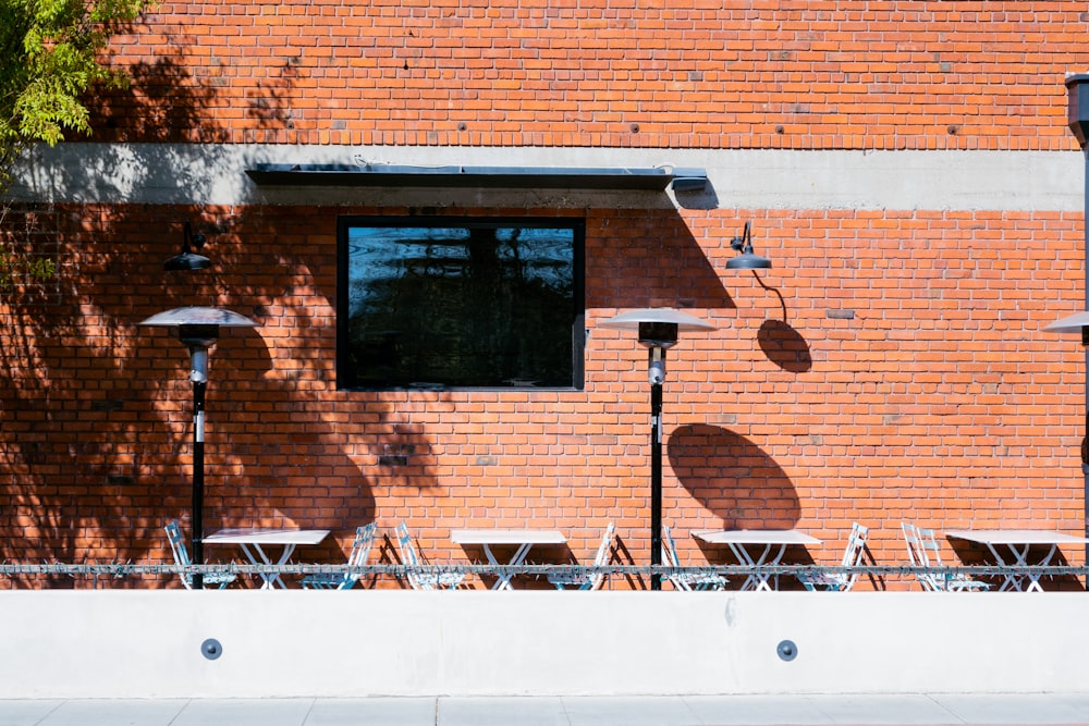 a red brick building with tables and chairs in front of it