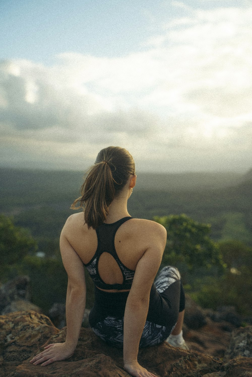 a woman sitting on top of a rock