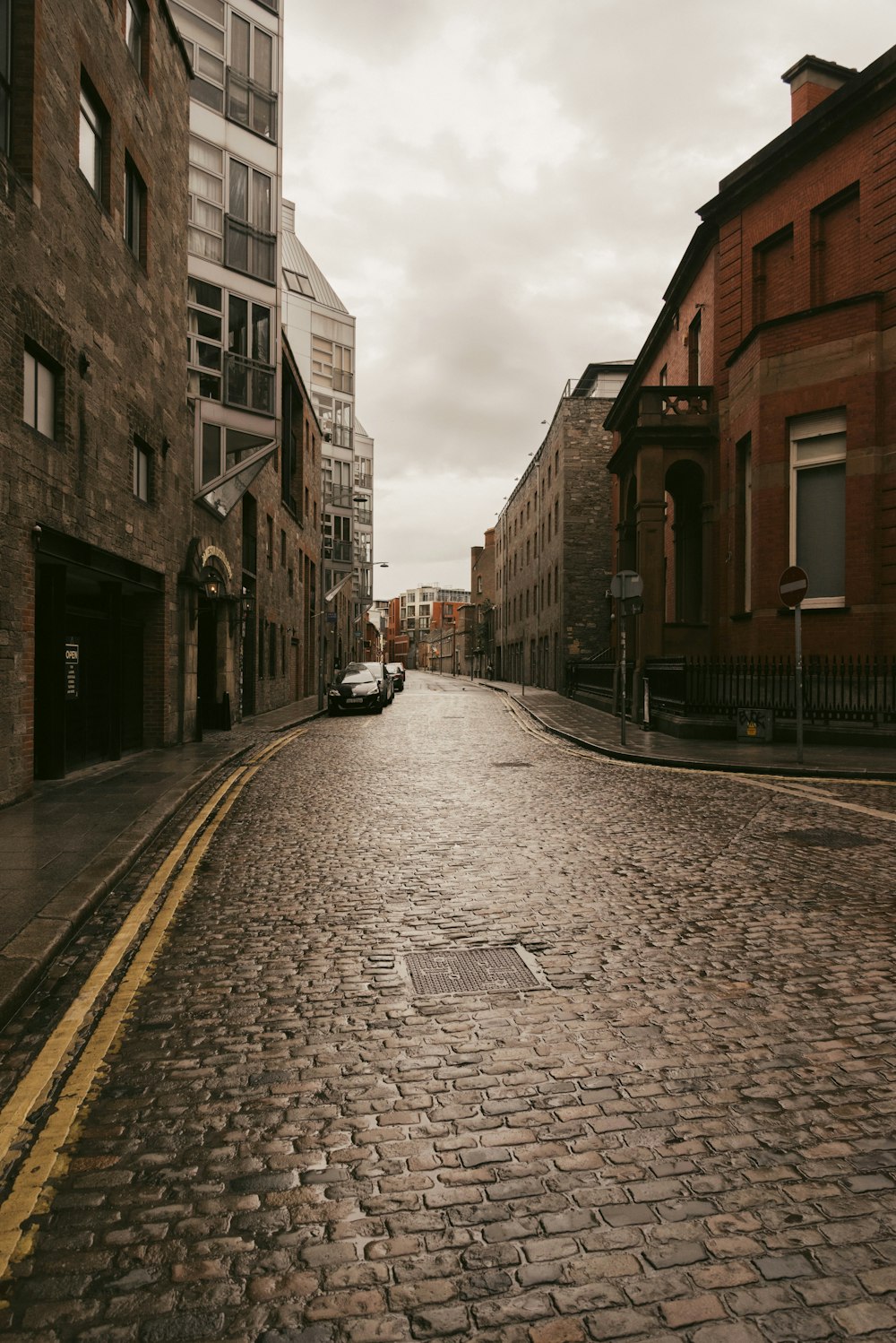 a car is parked on a cobblestone street