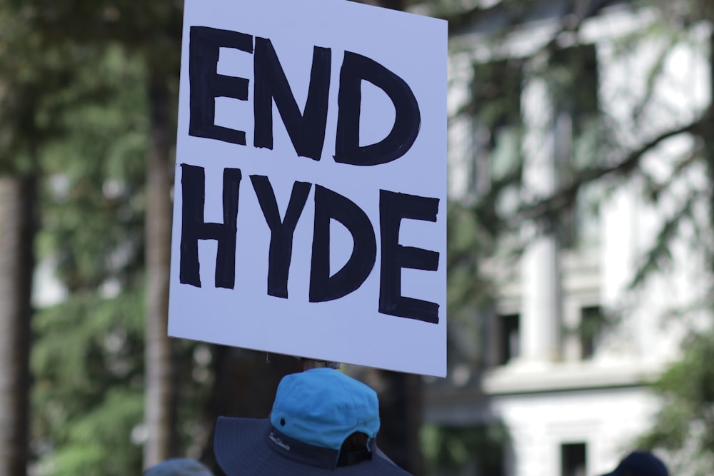 a person holding a sign that says end hyde