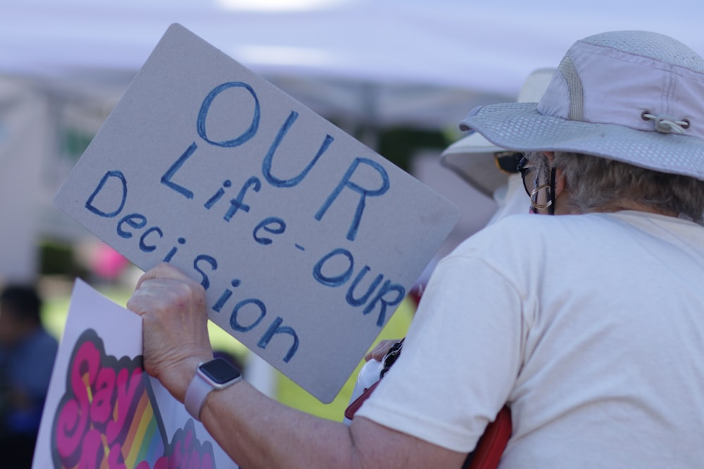 a man holding a sign that says our life - our decision