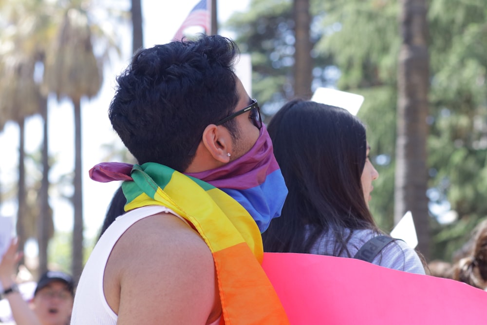 a man with a rainbow scarf around his neck