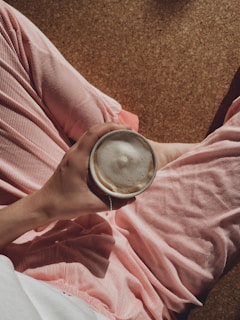a person is holding a cup of coffee