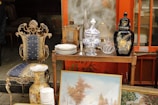 a table topped with a painting next to a chair