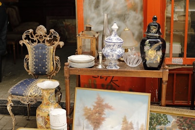 a table topped with a painting next to a chair