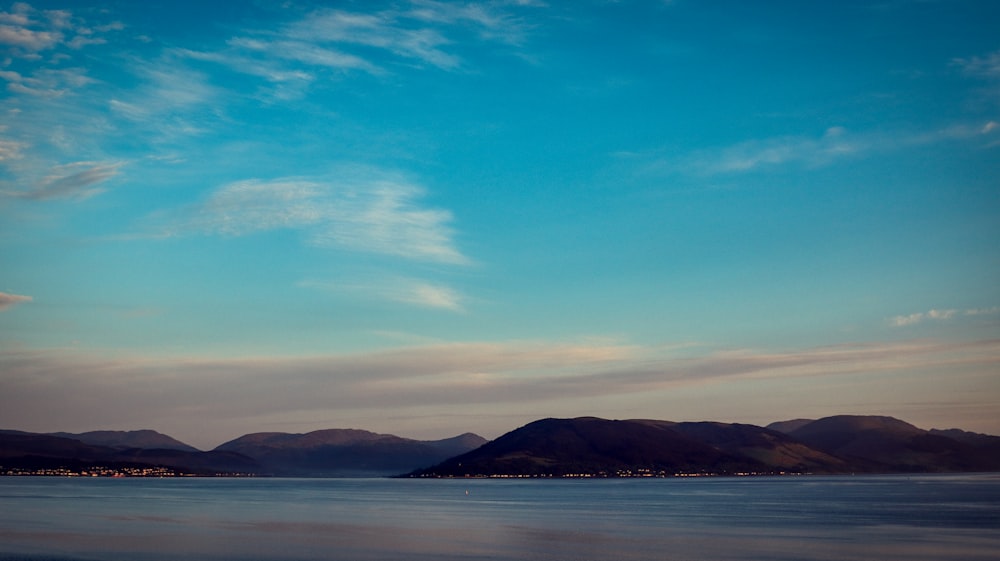 a large body of water with mountains in the background