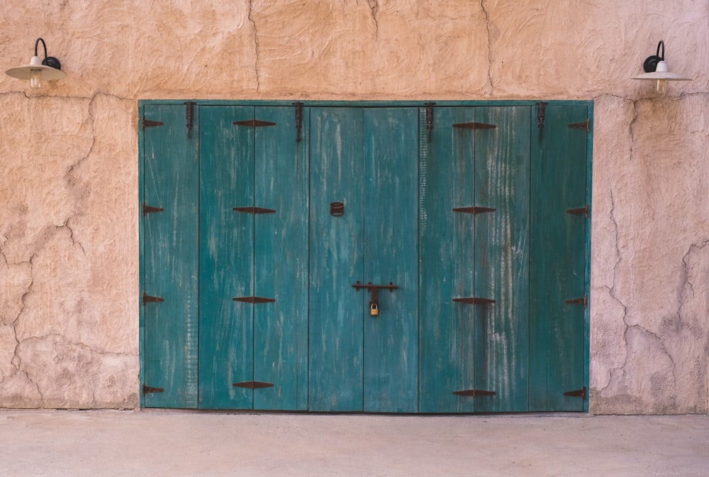 a green door with two lights on each side of it