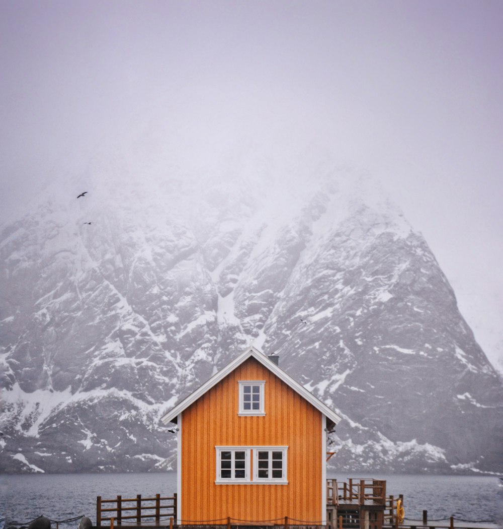 a red house with a mountain in the background