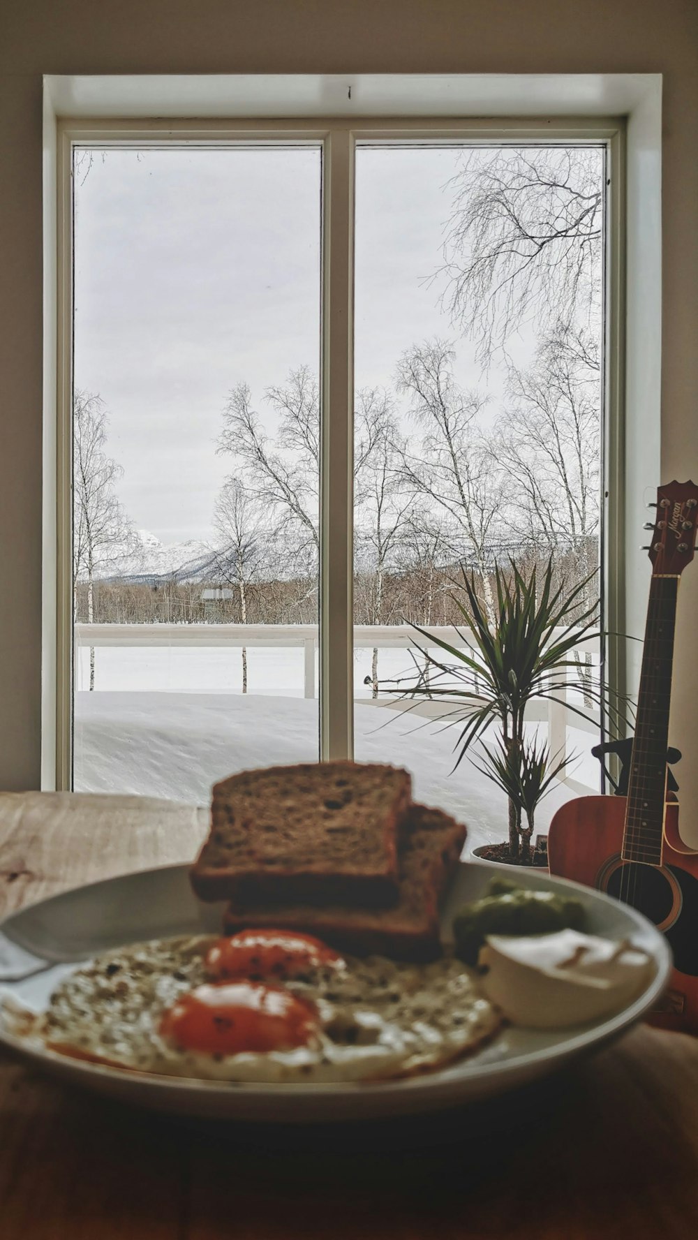 a plate of food on a table in front of a window