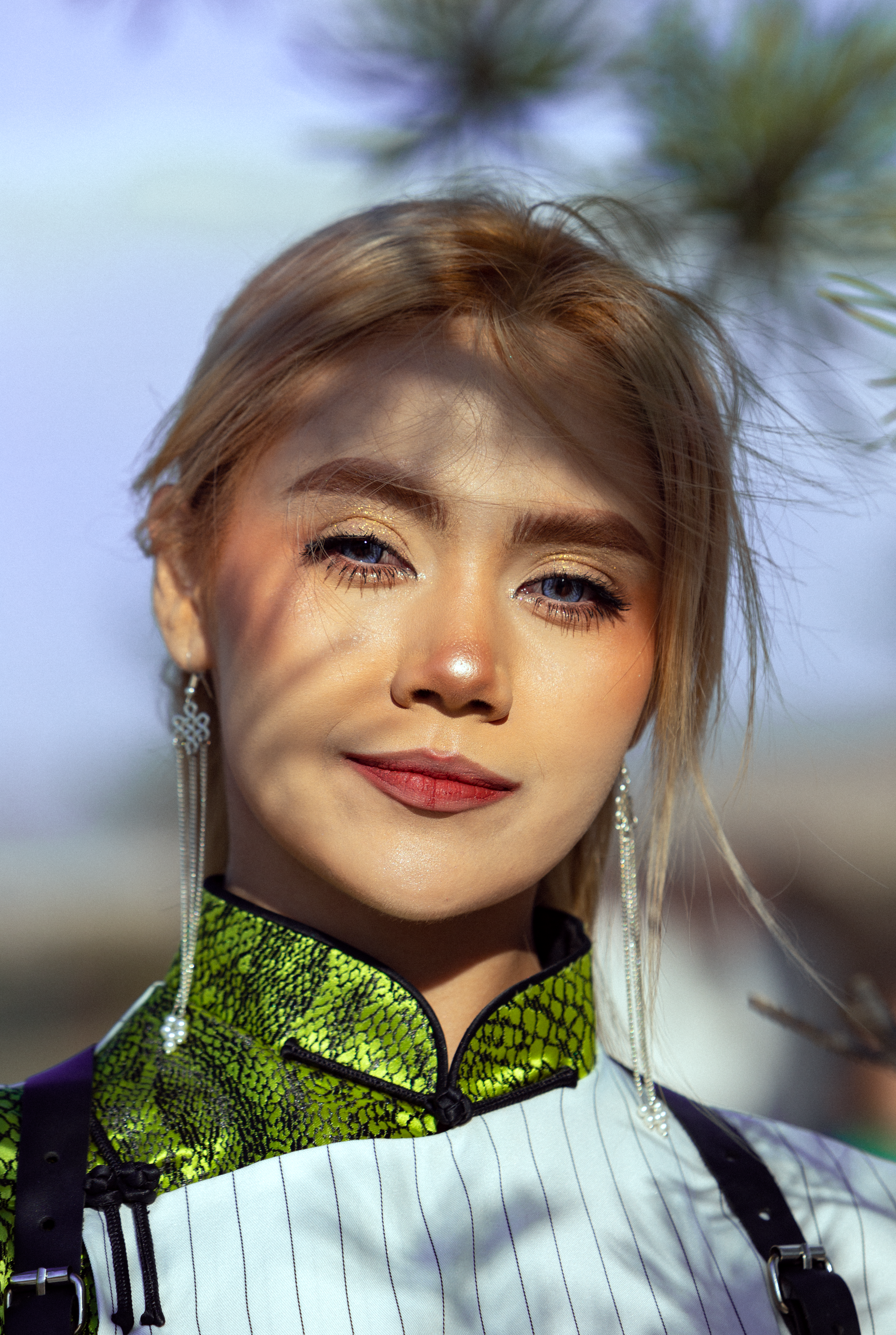 a woman with a green and white shirt and earrings