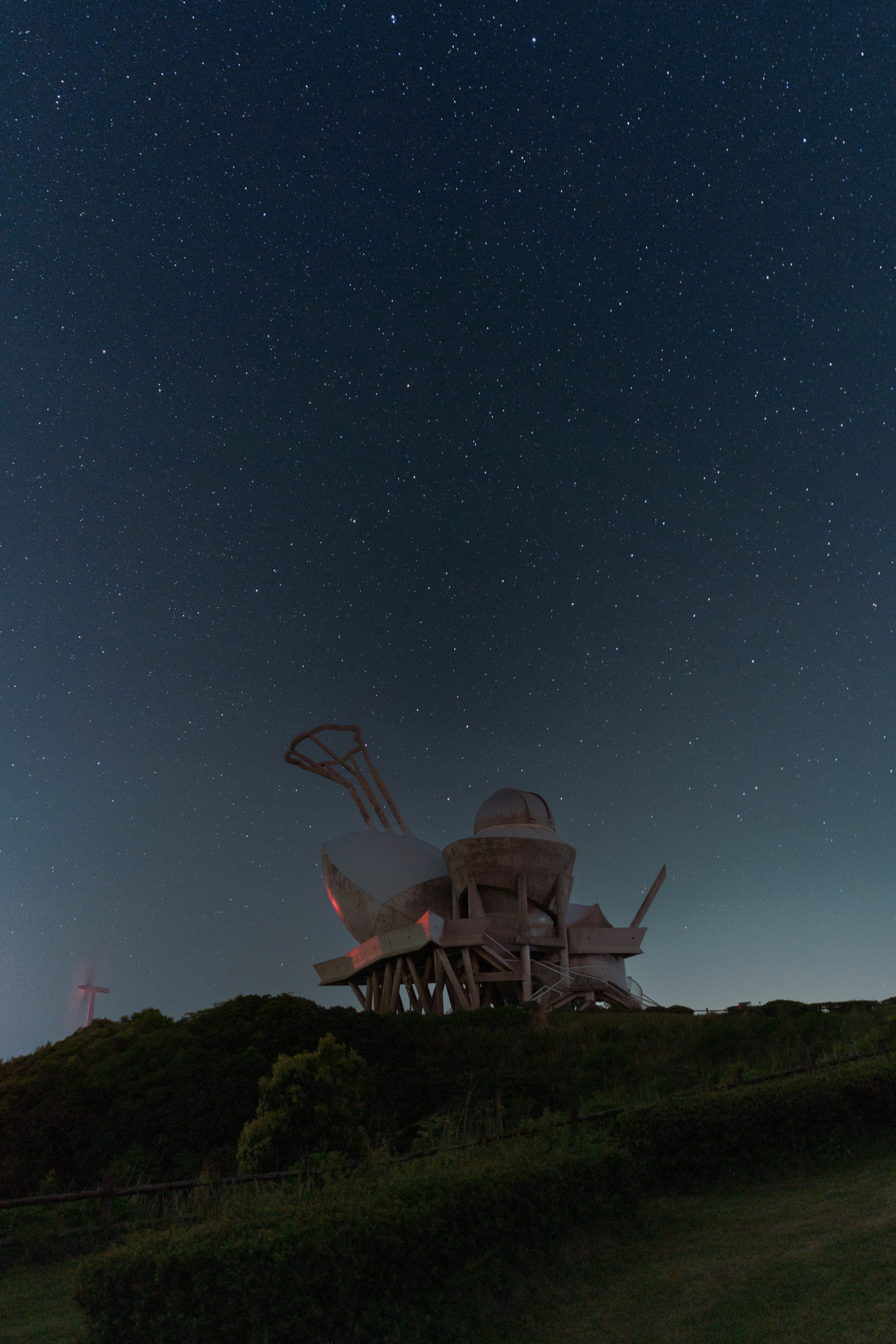 a very large structure sitting on top of a hill under a night sky