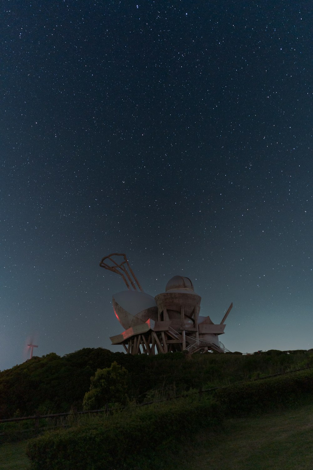 a very large structure sitting on top of a hill under a night sky