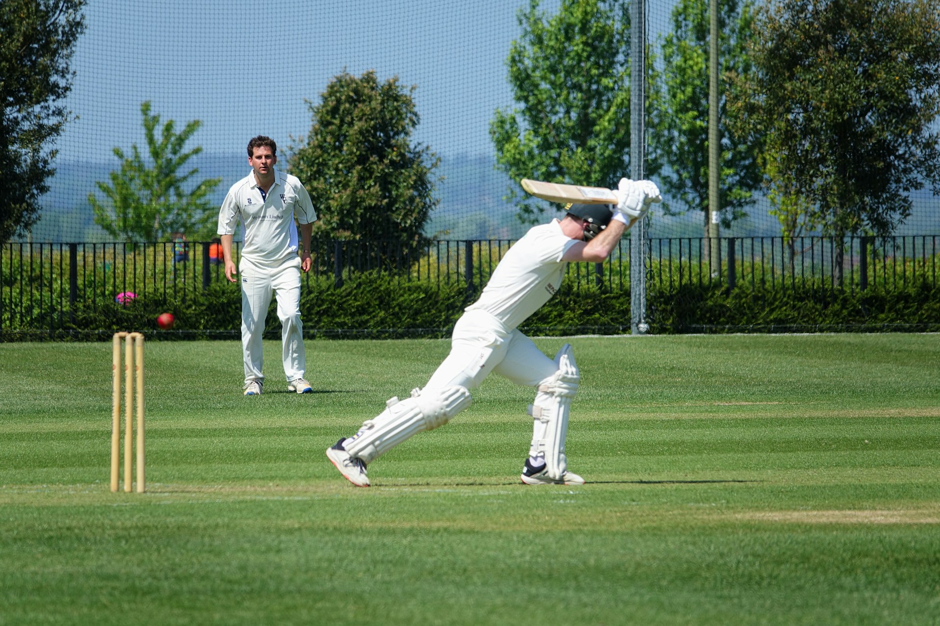 two men playing a game of cricket on a field
