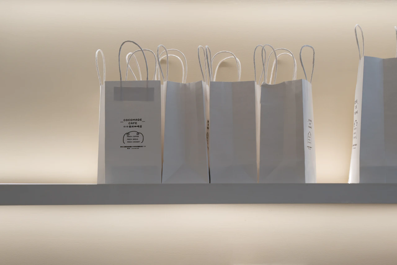 A row of packed bags staged on a shelf, online orders waiting for the customers who placed them