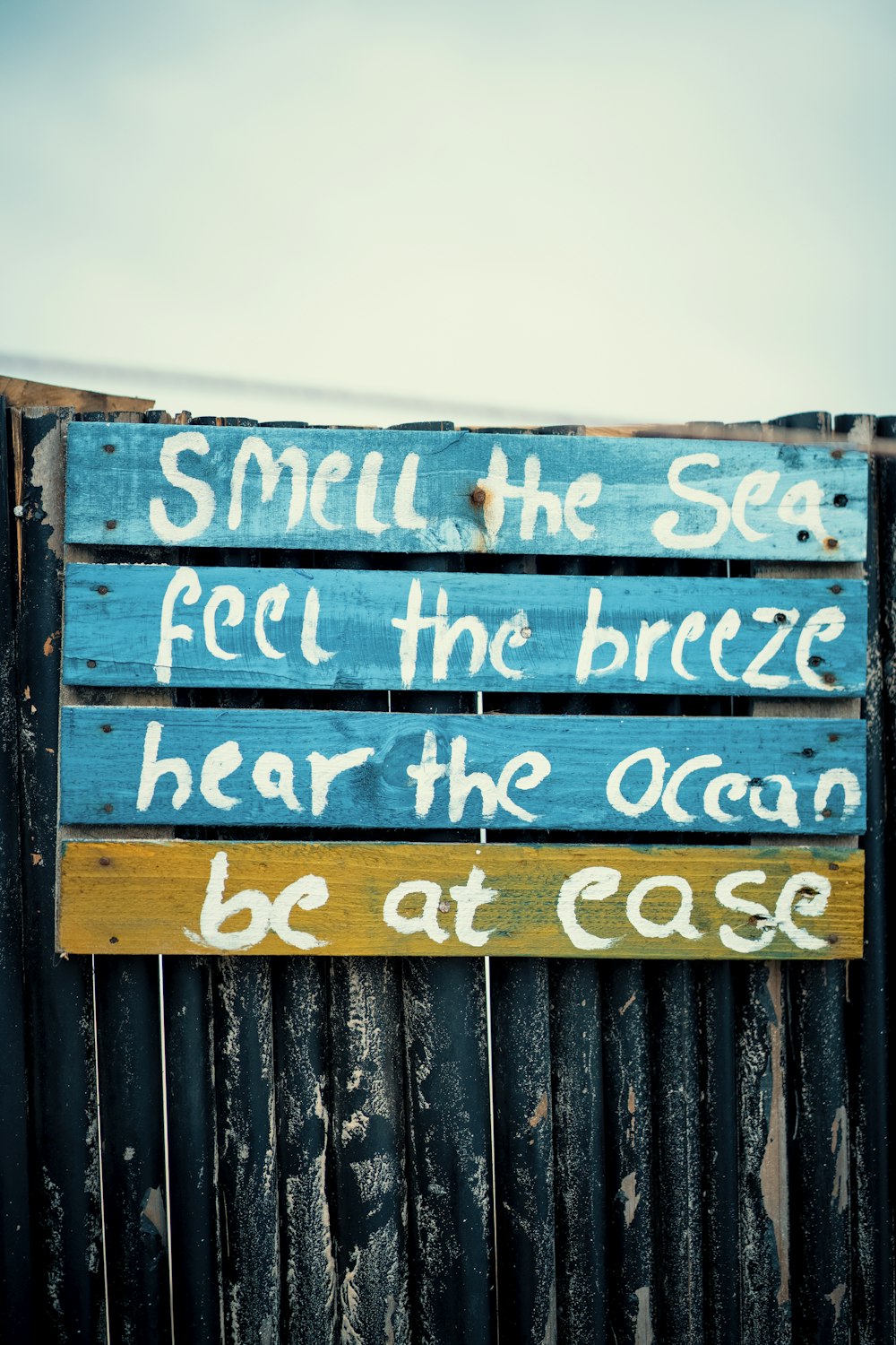 a wooden sign that says smell the sea feel the breeze hear the ocean be at