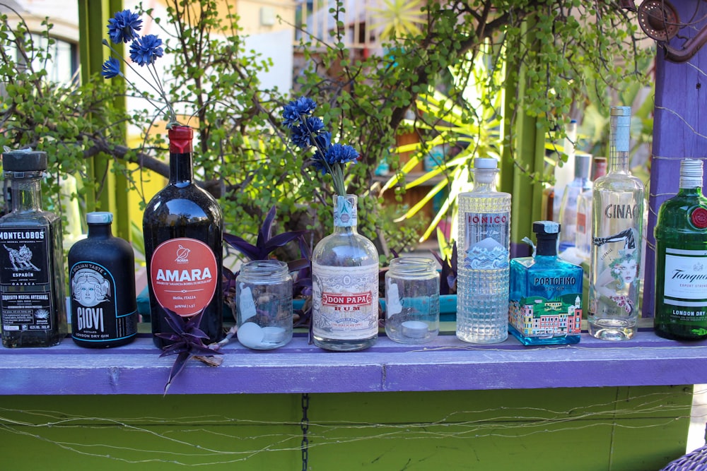 a purple table topped with lots of bottles of liquor