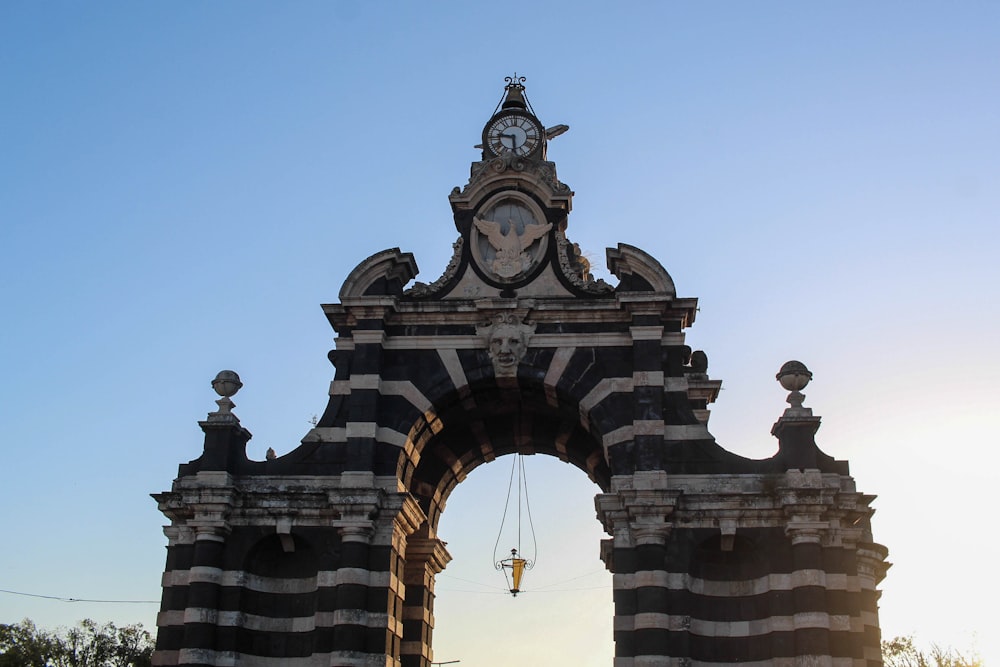 a clock on top of a black and white arch