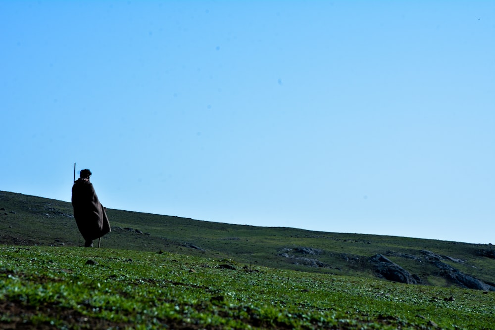 a person standing in a field with a coat on