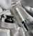 Two skincare product bottles are displayed on a textured, white fabric surface. One is a round jar labeled 'Multi Tea Serum', featuring a shiny silver lid. The other is a cylindrical bottle labeled 'Advanced Night Booster', also with silver accents.