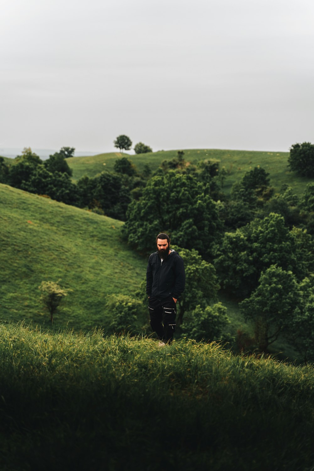 a man standing on top of a lush green hillside