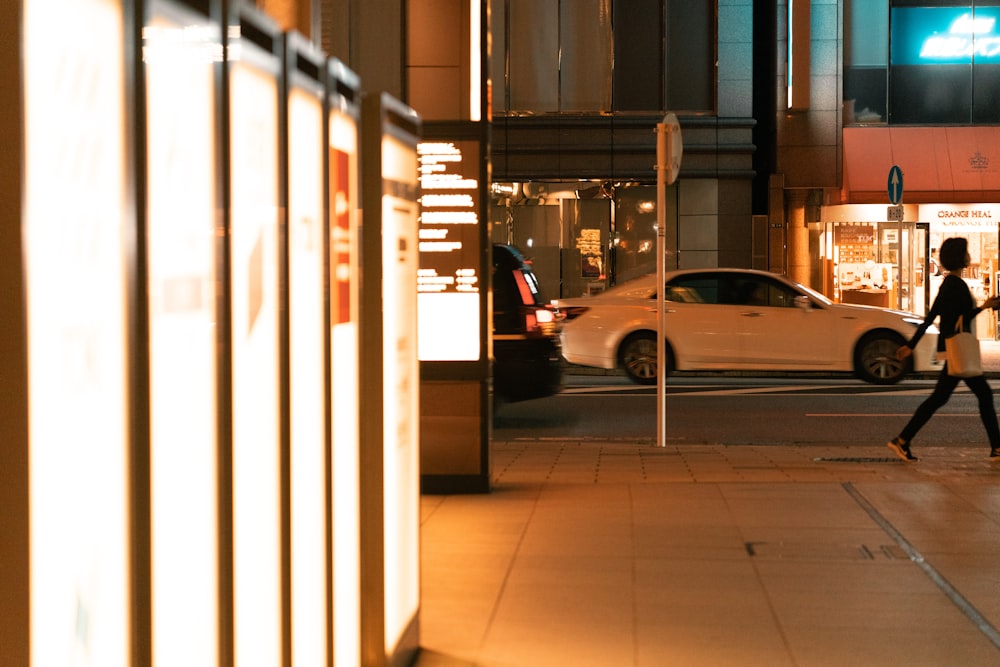 a woman walking down a street at night