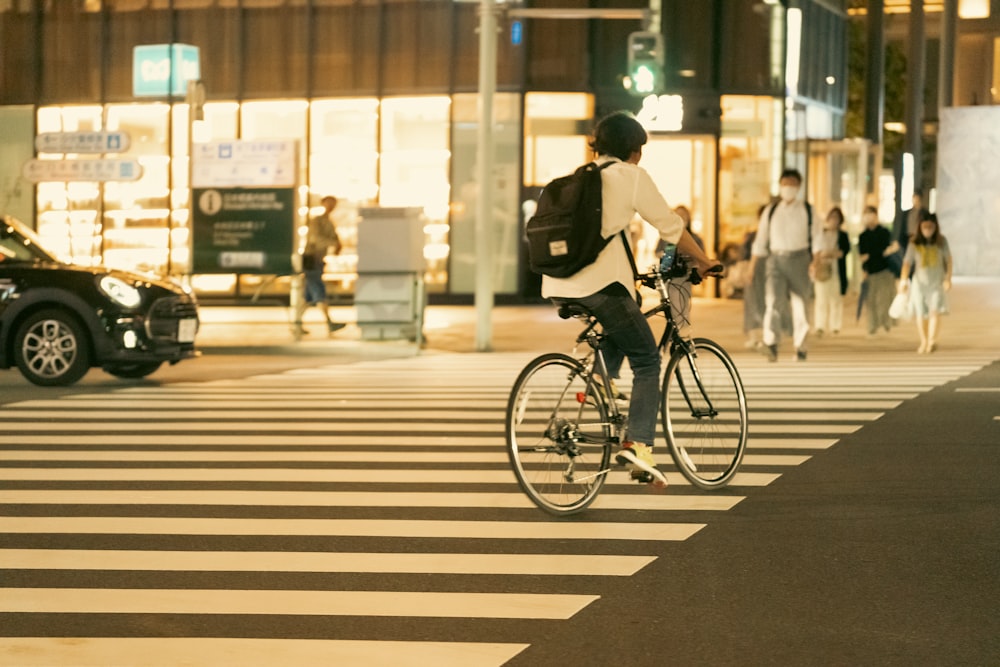 a man riding a bike across a cross walk