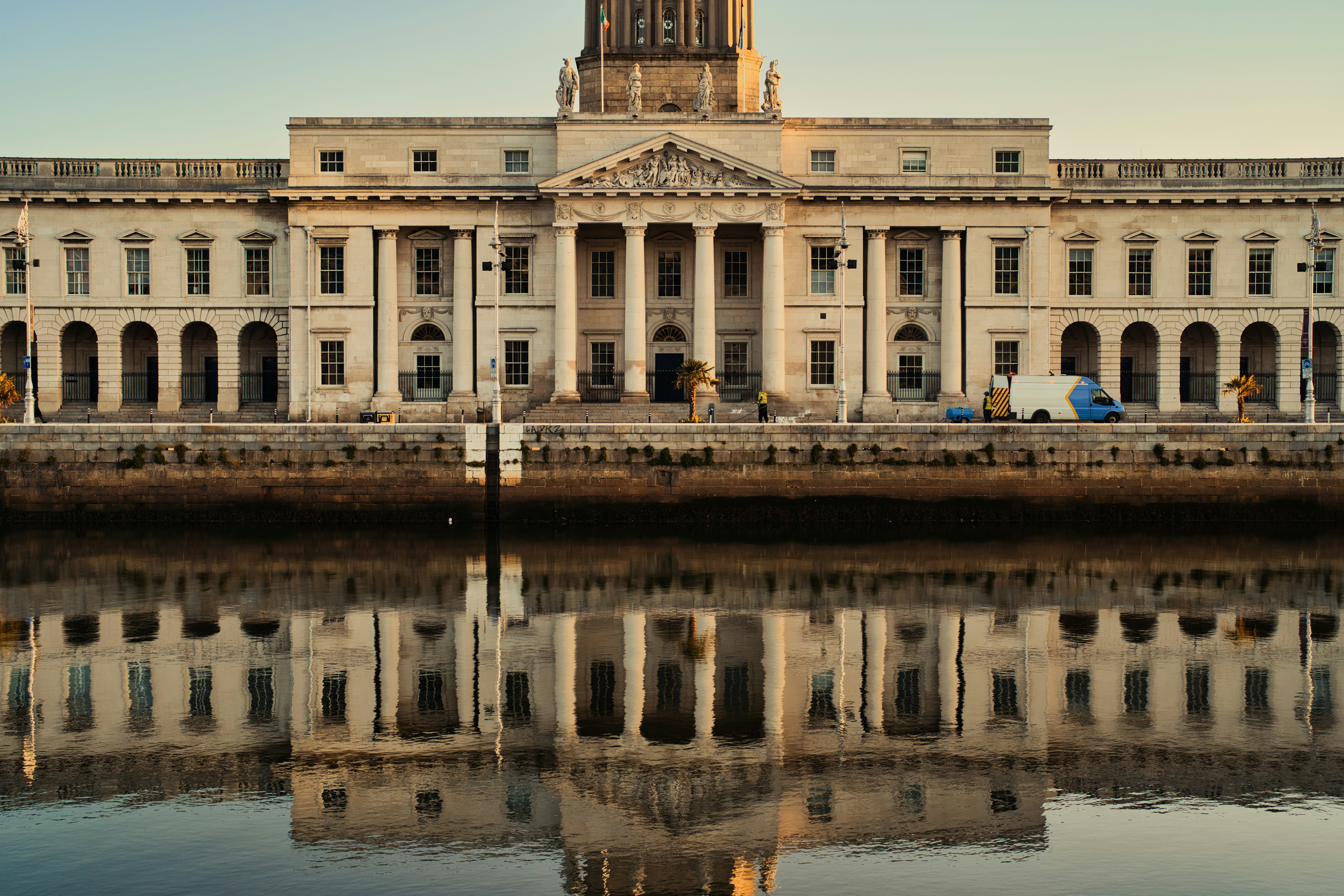 a large building with a clock tower next to a body of water, 