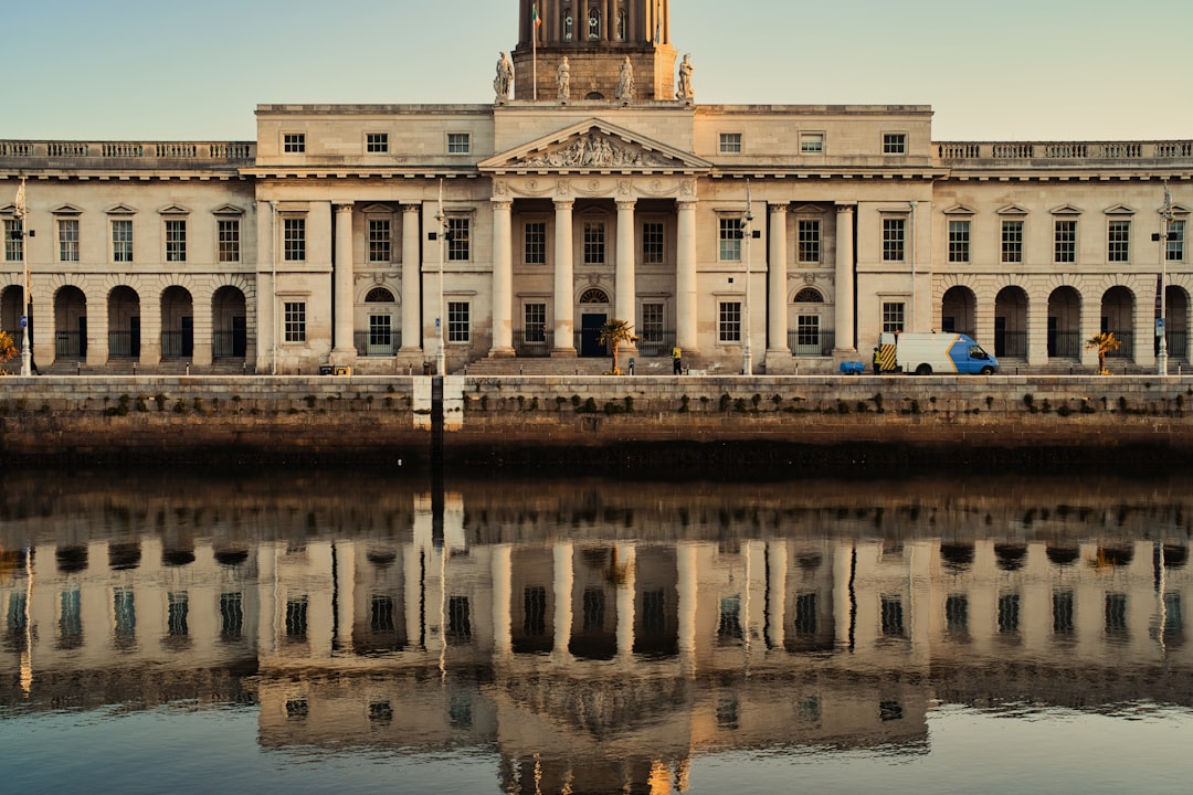 a large building with a clock tower next to a body of water,