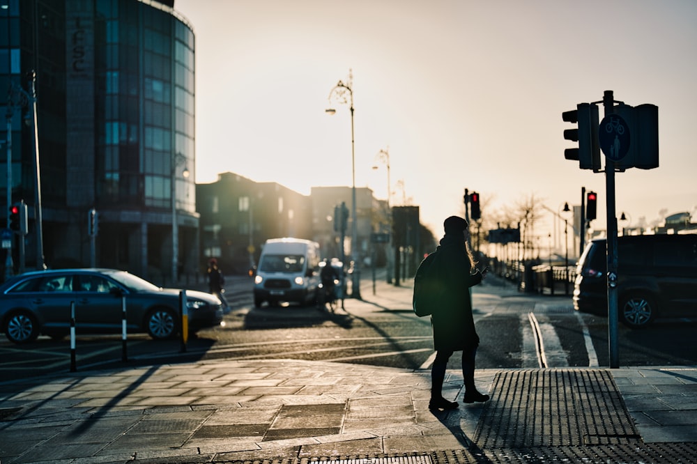 a person walking across a street next to a traffic light