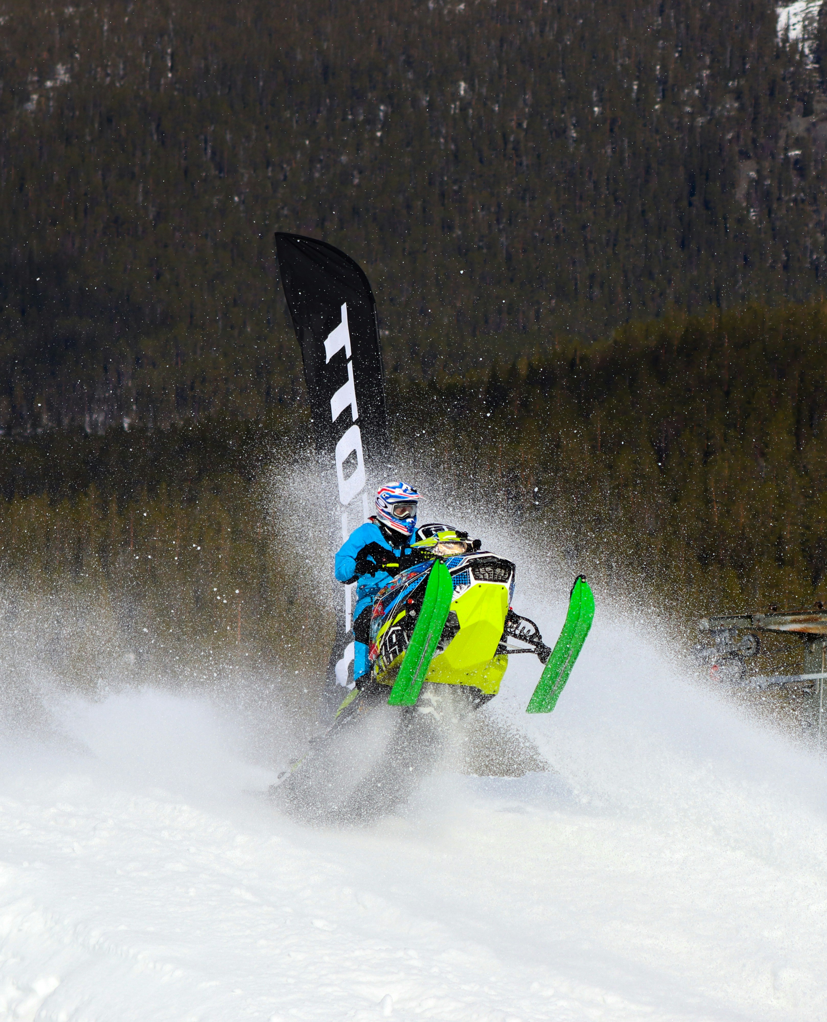 a man riding a snowboard down the side of a snow covered slope