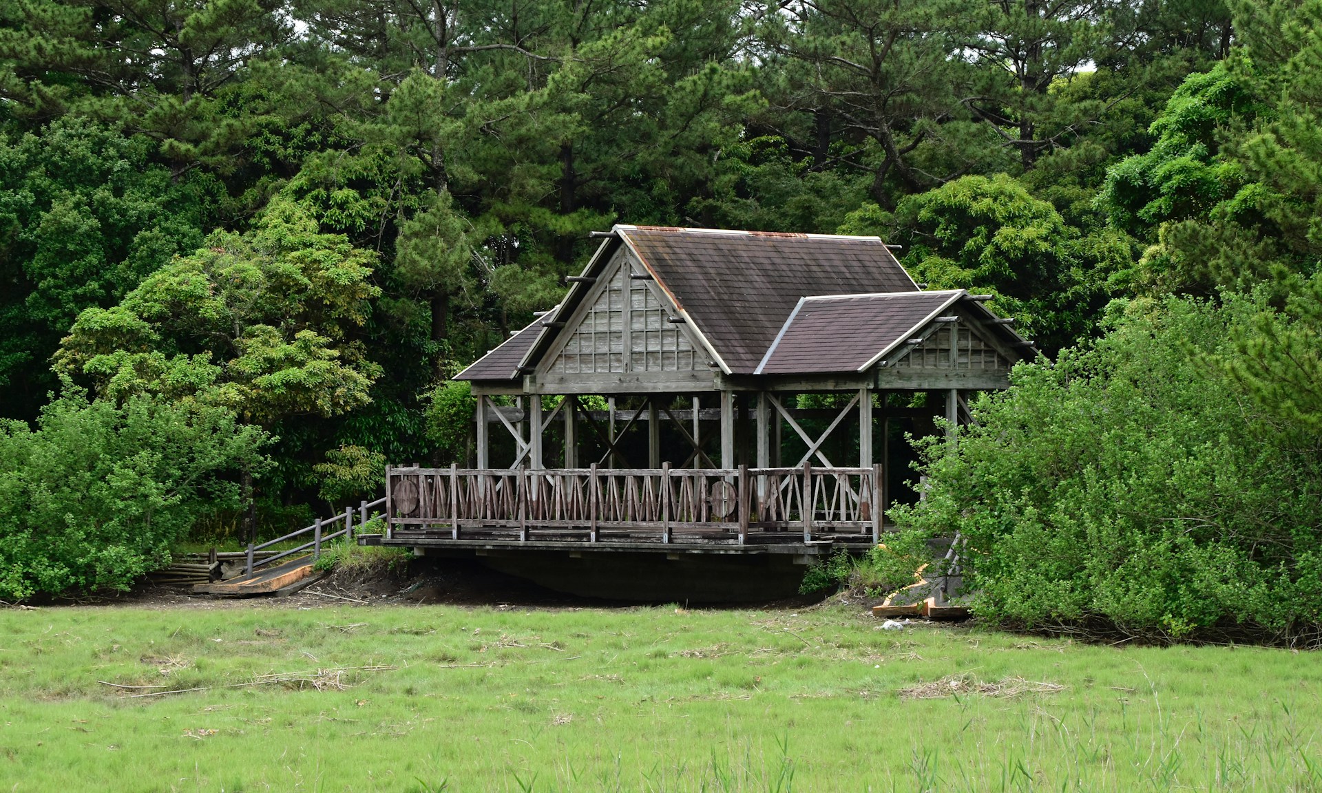 a wooden house sitting on top of a lush green field
