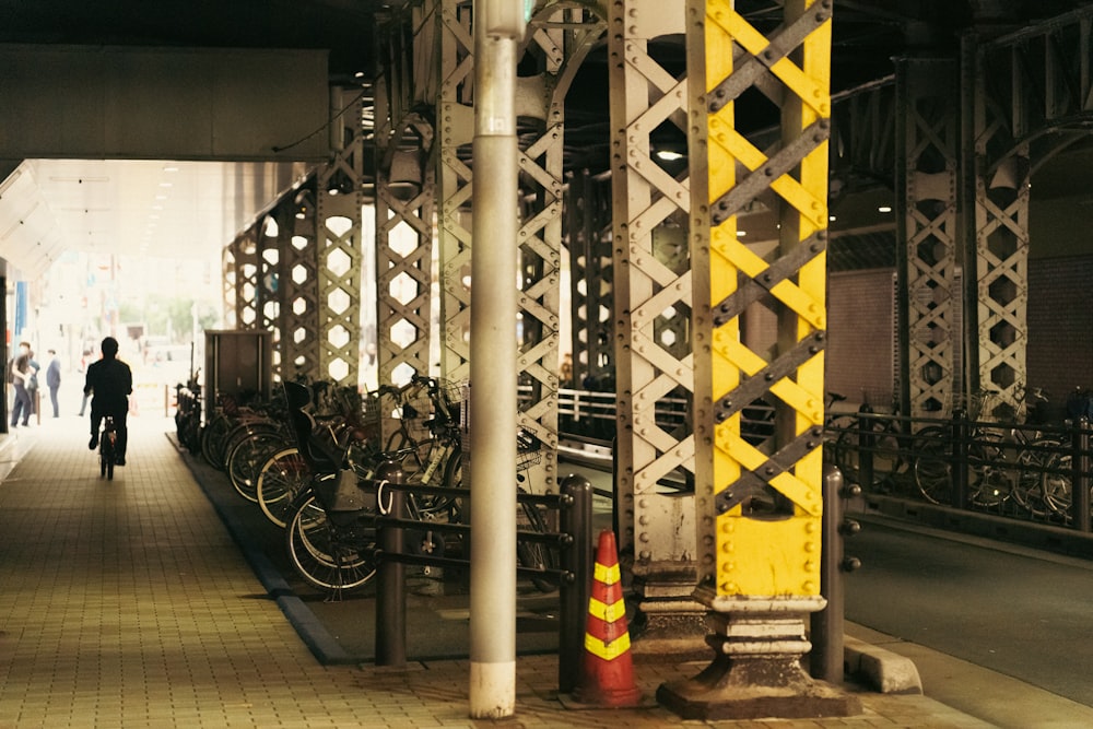 a man walking down a sidewalk next to a bunch of bikes